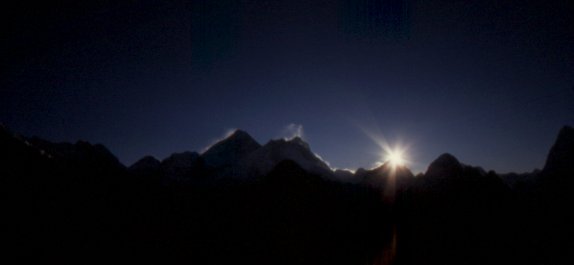 il sole sorge dietro le cime dell'Everest, del Lhotse e del Makalu